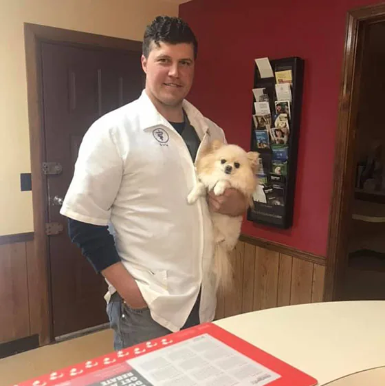 Veterinarian holding a small dog patient at Holt Animal Clinic